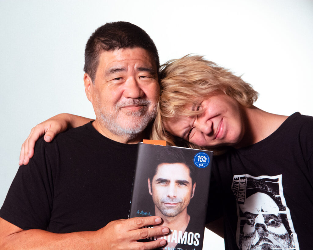 Ken Hada and Apollo Hada holding the new book from lifelong friend John Stamos.